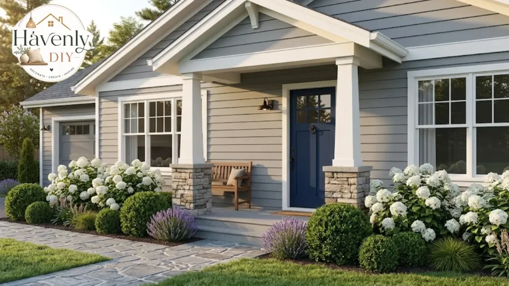Gray house front porch with a navy door, black hardware and white hydrangeas